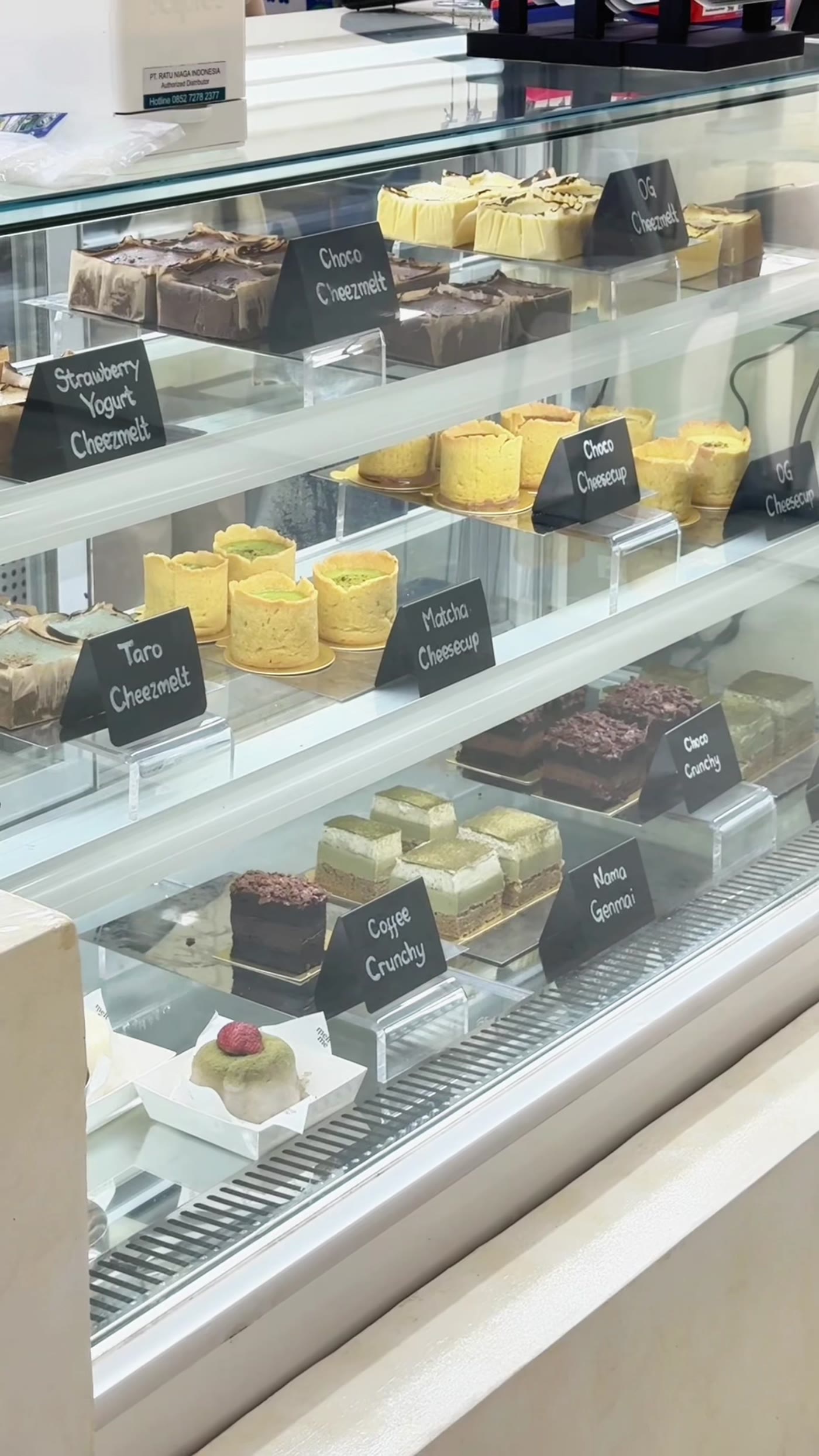 Dessert display case showing cheezmelt cheesecakes and melty cheese cups